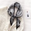 Elegant black and white zebra-patterned silk scarf perfect for stylish fashion accessories.