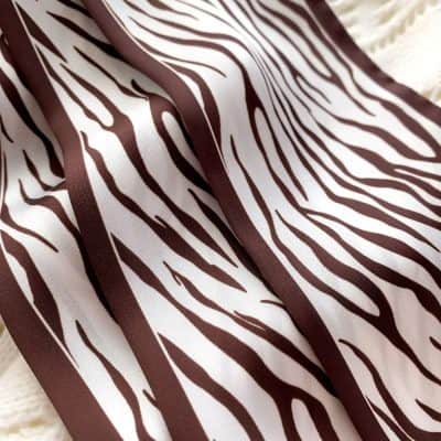 Zebra pattern fabric featuring bold brown and white stripes, perfect for fashion and interior decor accessories. Durable and stylish material ideal for sewing projects or statement clothing pieces.