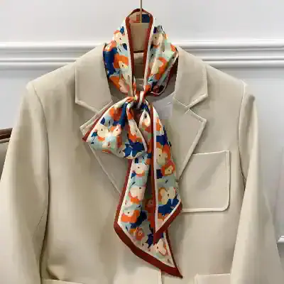 Versatile floral-patterned silk scarf styled around a beige blazer, ideal for enhancing your fashion statement with sophistication and colorful appeal.