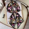 Elegant floral patterned silk scarf with vibrant pink, white, and yellow flowers on a black background, perfect for fashion accessories and stylish embellishments.