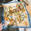Luxury women's silk scarf with iris and butterfly design, vibrant orange and green accents. Perfect for stylish accessories and gift-giving.