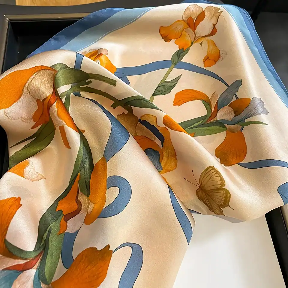 Elegant floral scarf with orange, cream, and green iris flower print and butterfly design, perfect for fashion accessories or gifting.