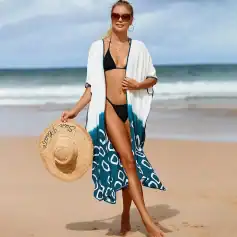 Woman in black bikini with beach cover-up holding a straw hat on sandy beach, promoting summer beach fashion, swimwear, and resort outfits at Monalisa Medical Store.
