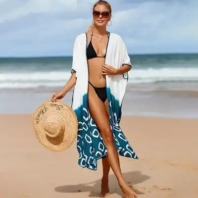 Woman in black bikini with beach cover-up holding a straw hat on sandy beach, promoting summer beach fashion, swimwear, and resort outfits at Monalisa Medical Store.