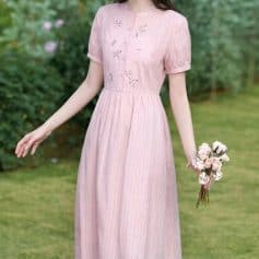 A lovely pink dress featuring delicate floral embroidery, short sleeves, and a flattering waistline, perfect for stylish occasions and outdoor events.