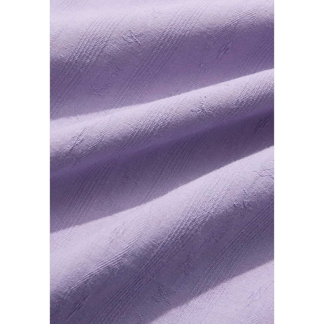 Close-up image of elegant purple fabric showcasing a smooth texture and subtle sheen, ideal for upscale apparel and tailored medical uniforms.