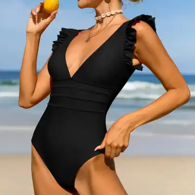 Stylish black swimsuit featuring ruffled shoulder accents, perfect for beachwear and swim fashion. Ideal for women seeking trendy, comfortable swimwear for summer vacations and pool days.
