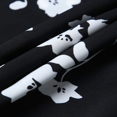 Detailed close-up of premium black and white floral-patterned fabric, optimized for medical apparel, durable, comfortable, and stylish, perfect for scrubs and hospital uniforms.