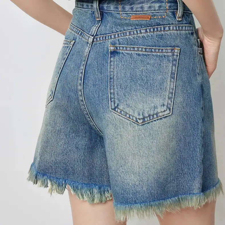 Comfortable blue denim shorts with frayed edges, perfect for casual wear and outdoor activities. High-quality, fashionable, and designed for a comfortable fit around the waist and hips.