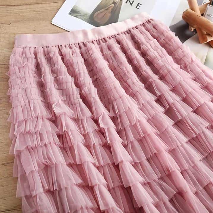 Elegant pink tulle skirt with multiple ruffled layers, perfect for fashion-forward ladies seeking chic and trendy clothing options. Ideal for special occasions or stylish everyday wear.