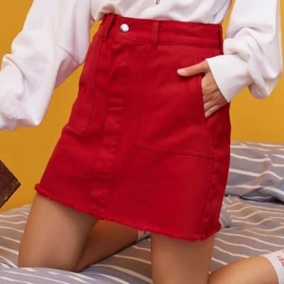 Bright red denim skirt with a high waist, front pockets, and frayed hem, perfect for casual and chic outfits. Made from durable, comfortable fabric, ideal for daily wear and fashion-forward looks.