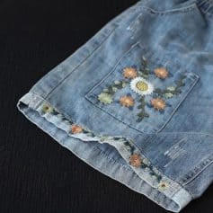 Decorative floral embroidery on back pocket; stylish distressed denim fabric; perfect for casual summer wear; trendy women's fashion at Monalisa Medical.