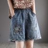 Embroidered denim shorts with floral patchwork and distressed details, perfect for stylish casual wear. Features an elastic waistband and deep pockets for comfort.