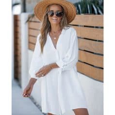 Woman in white summer dress wearing a sun hat and sunglasses, enjoying a sunny day outdoors at Monalisa Store, showcasing stylish eyewear and fashionable accessories.