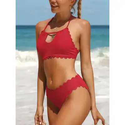 Bright red scalloped-edge bikini set with textured fabric, perfect for beach and pool outings, featuring stylish halter top and high-waisted bottoms for a flattering fit.