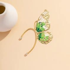 A stunning gold-tone butterfly brooch featuring vivid green enamel wings decorated with sparkling crystals, ideal for fashion and accessory enthusiasts.