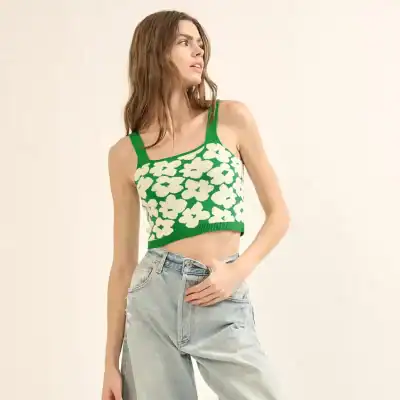Stylish green floral crop top with wide shoulder straps, perfect for warm weather and casual fashion, paired with light-wash jeans for a trendy look.