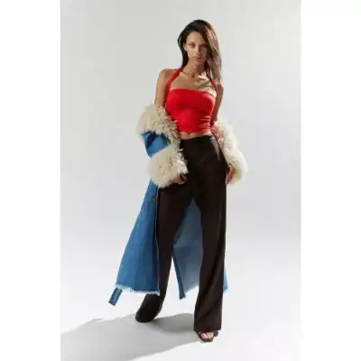 Stylish woman modeling high-fashion casual outfit with a red crop top, black wide-leg trousers, and a blue oversized denim jacket with fur collar, perfect for fashion-forward looks.