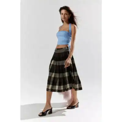 A fashionable woman in a light blue ruched crop top and plaid midi skirt, showcasing trendy summer clothing perfect for stylish outings and casual wear.