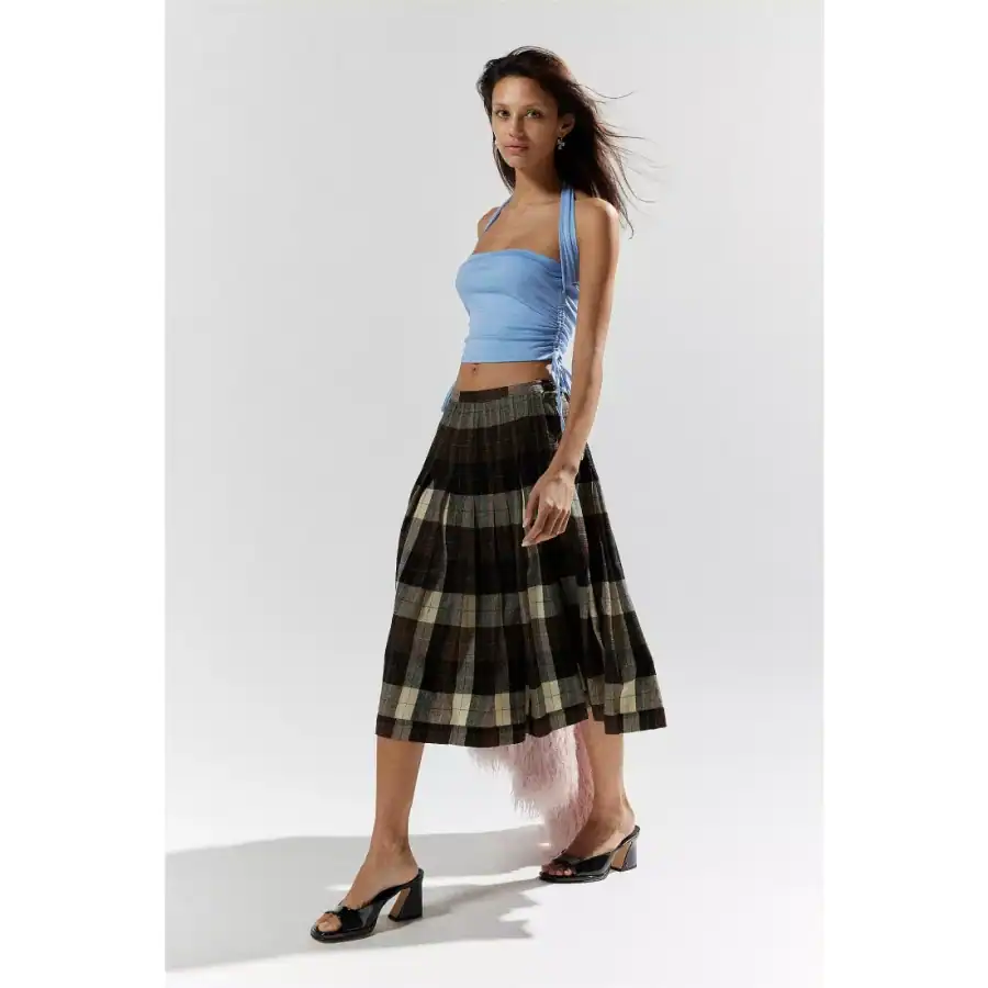 A fashionable woman in a light blue ruched crop top and plaid midi skirt, showcasing trendy summer clothing perfect for stylish outings and casual wear.
