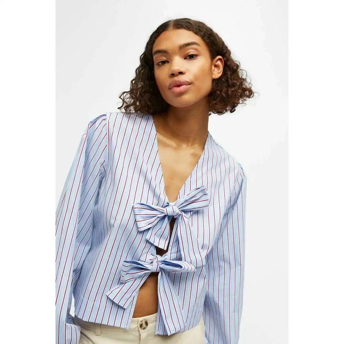 Elegant women's striped top featuring a chic bow tie at the front, perfect for casual or office wear. Made from comfortable, high-quality fabric, designed to enhance your fashion statement.