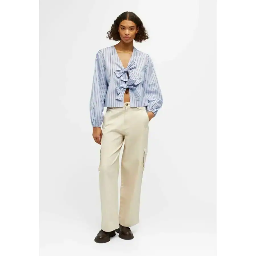 Stylish women's blue and white striped blouse with bow details, perfect for casual or office wear. Comfortable and trendy, ideal for all-day wear.