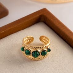 Luxurious gold ring featuring a series of polished green malachite cabochons, perfect for fine jewelry and elegant accessories.