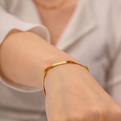 Close-up of a gold bracelet on a woman's wrist, emphasizing luxury and fine jewelry. Ideal for promoting opt focused on high-quality accessories.