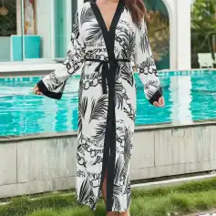 Stylish black and white patterned kaftan with floral and leaf design, perfect for poolside or beachwear. Made for women seeking comfort and style with a relaxed fit.