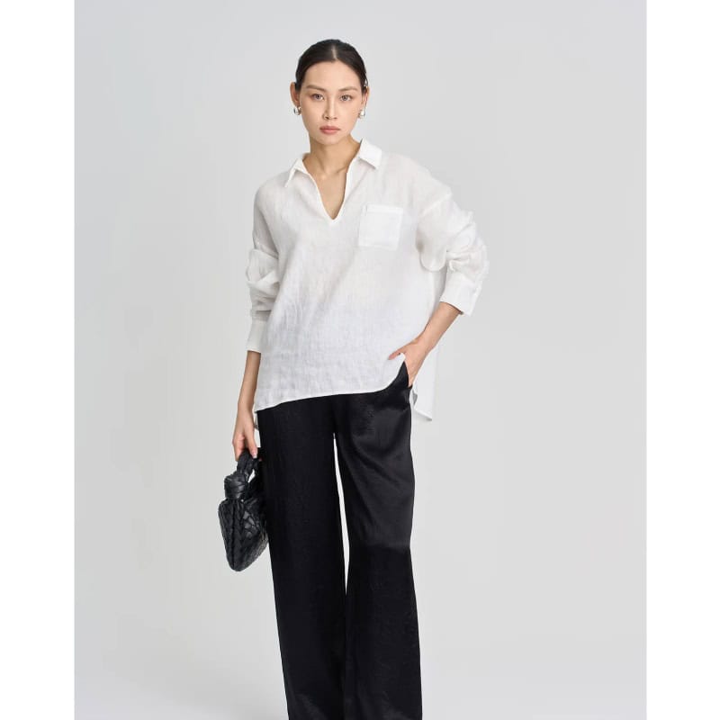 Elegant women's white blouse with a pocket, long sleeves, and a V-neck, perfect for professional and casual wear. Crafted with comfortable fabric for versatile styling.