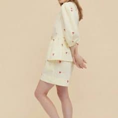 Beautiful women's cream-colored dress with red bow embroidery, puff sleeves, and a peplum waist, perfect for stylish casual or semi-formal wear.