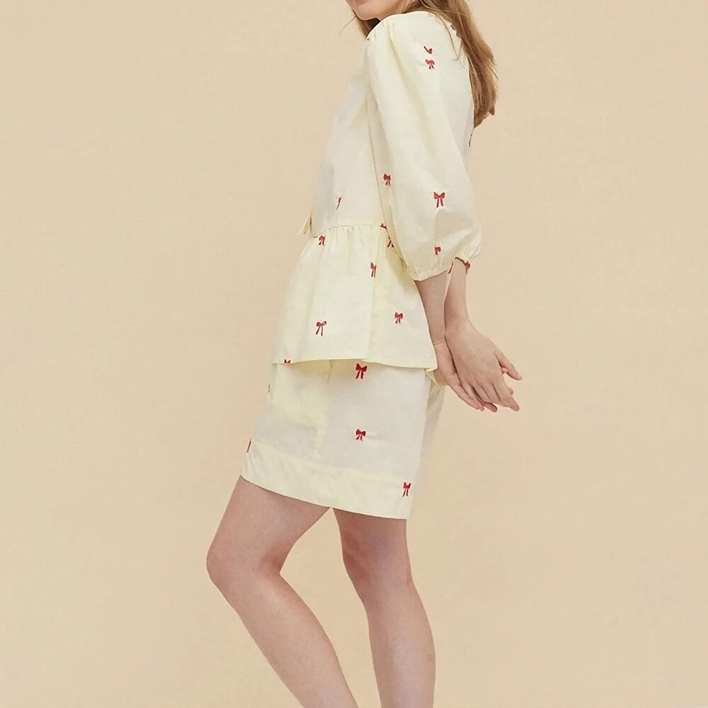 Beautiful women's cream-colored dress with red bow embroidery, puff sleeves, and a peplum waist, perfect for stylish casual or semi-formal wear.