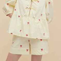 Comfortable women's pajama set with red bow print, soft fabric, relaxed fit, perfect for bedtime. Includes a loose top and matching shorts for a stylish, comfy look.