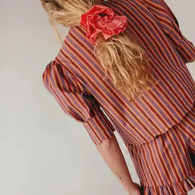 Bright, colorful striped dress featuring ruffle accents and puffed sleeves, ideal for stylish occasions and elegant wardrobe choices.