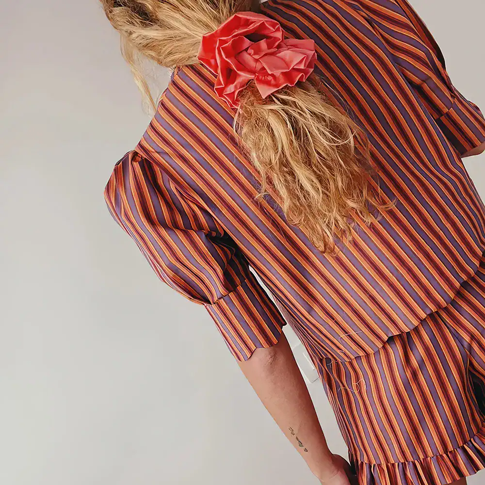 Bright, colorful striped dress featuring ruffle accents and puffed sleeves, ideal for stylish occasions and elegant wardrobe choices.