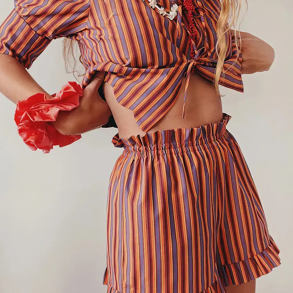 Colorful striped blouse and shorts perfect for summer and casual wear, styled with accessories.