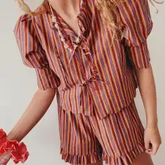 Brightly colored striped silk pajama set with ruffle details, perfect for cozy sleepwear or loungewear at Monalisa Store.