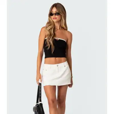 Minimalist black women's crop top with white trim, stylish and perfect for summer outfits, paired with a white denim skirt for a chic and trendy look.