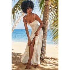 Young woman in summer dress by the beach, enjoying sunny weather.