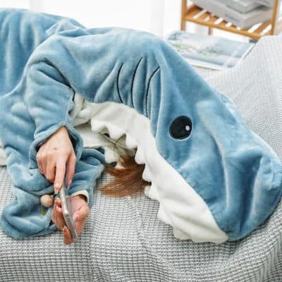 Girl in adorable blue whale costume, relaxing on a sofa, taking a selfie. Cozy, fun, and comfortable loungewear perfect for home relaxation.
