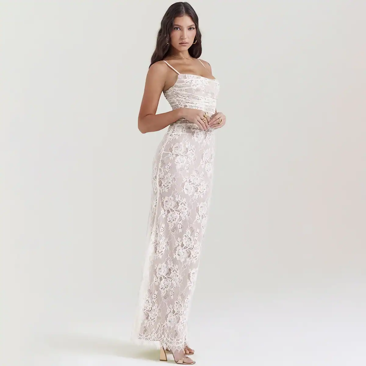 Elegant white lace jumpsuit with delicate floral patterns, perfect for stylish occasions. Features a fitted design with spaghetti straps and a classy long length.