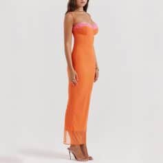 A stunning orange gown featuring pink lace accents at the bust, modern fitted silhouette, spaghetti straps, and a sheer hem, perfect for formal occasions.