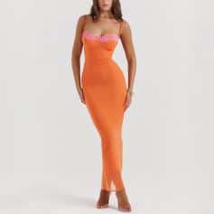 Stylish orange maxi dress featuring pink lace accents, perfect for fashionable outings and special occasions. The form-fitting design enhances your silhouette, paired with clear heels for a chic look.