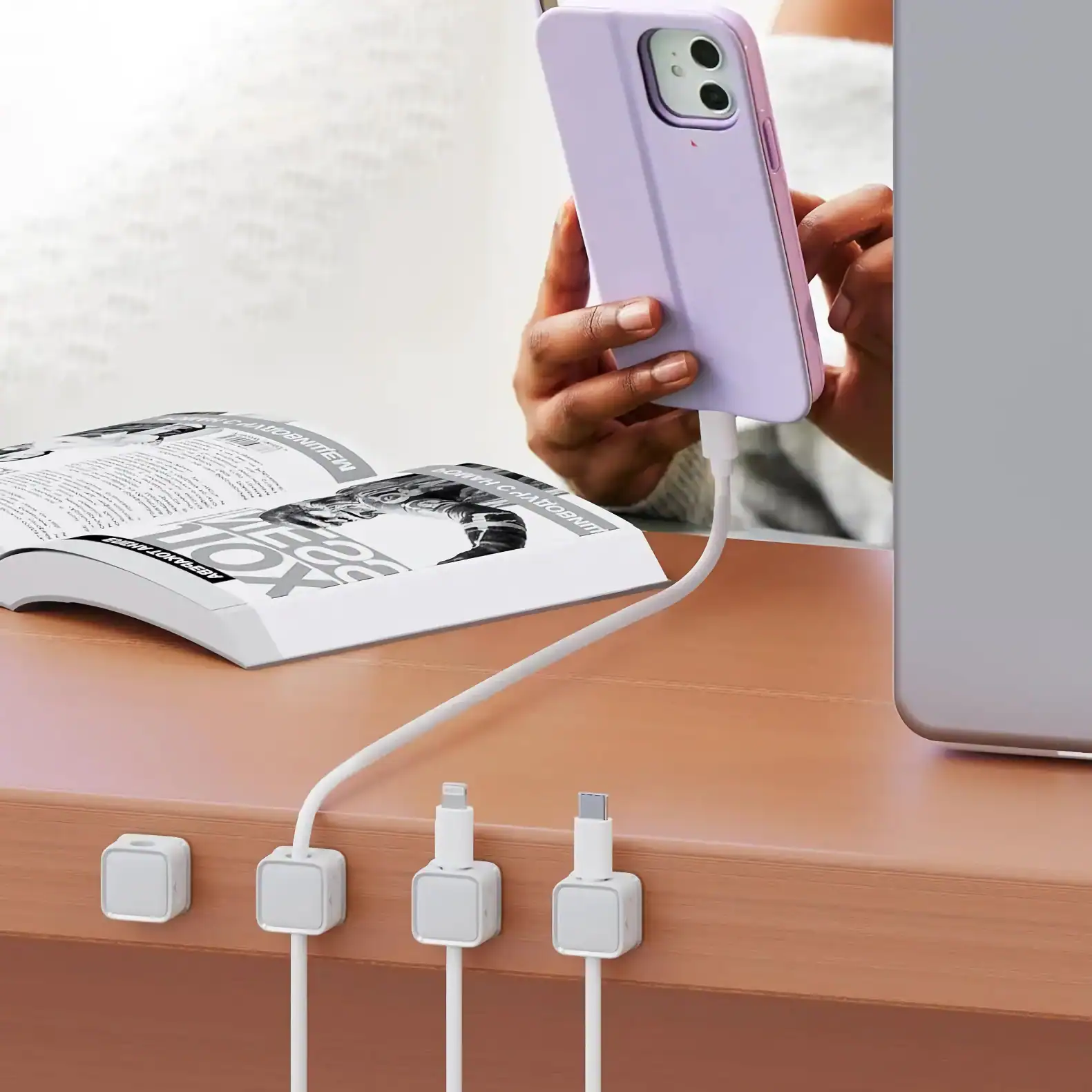 Close-up of a person connecting their smartphone to a fast charging cable at a modern workspace, emphasizing quick and efficient mobile device charging solutions.