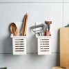 Utensils in white wall-mounted containers, including wooden spatulas, chopsticks, and a vegetable peeler. Perfect for organizing kitchen tools and maintaining a tidy cooking space.