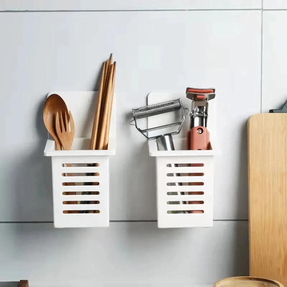 Utensils in white wall-mounted containers, including wooden spatulas, chopsticks, and a vegetable peeler. Perfect for organizing kitchen tools and maintaining a tidy cooking space.