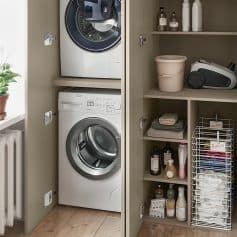 Efficient laundry room with stacked washing machine and dryer, organized shelves with detergent bottles, laundry baskets, and cleaning supplies for a tidy home environment.