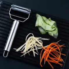 Efficient knife sharpener on a black surface with colorful vegetable peels, ideal for maintaining blades used in optometry and eyewear customization.
