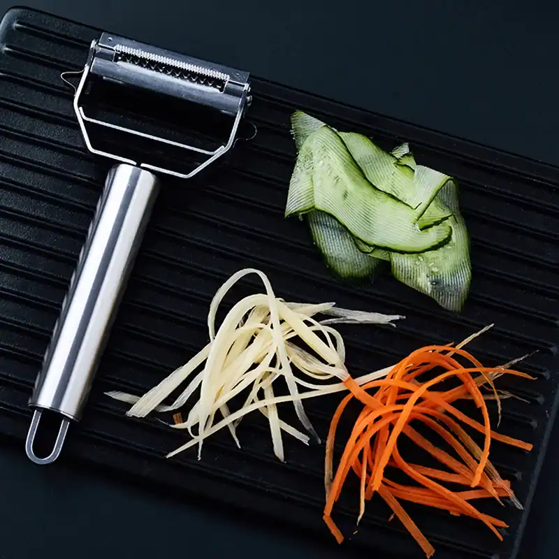 Efficient knife sharpener on a black surface with colorful vegetable peels, ideal for maintaining blades used in optometry and eyewear customization.