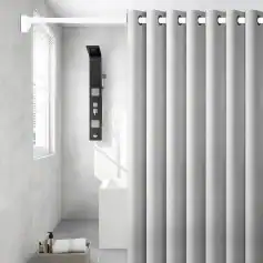 Elegant bathroom shower with white curtains, black shower panel, and minimalist decor, creating a clean and contemporary look for home or spa settings.